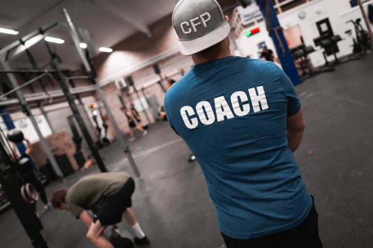 Coach som handleder en medlem under personlig träning